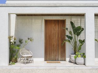 关上现代布宜诺斯艾利斯家门前门两侧配有椅子和装饰植物