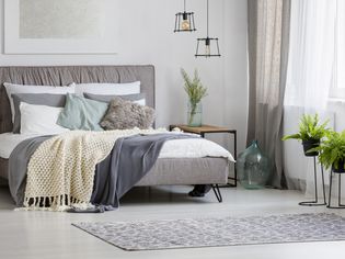 灰色现代卧室室内装饰王式床配有衬垫和毯子