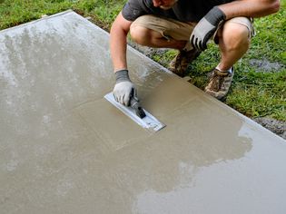 人用手浮平滑湿水泥板