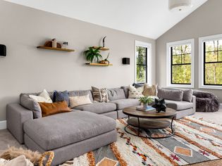 美起居室内有多色面积地毯、大沙发和丰富的自然拉网